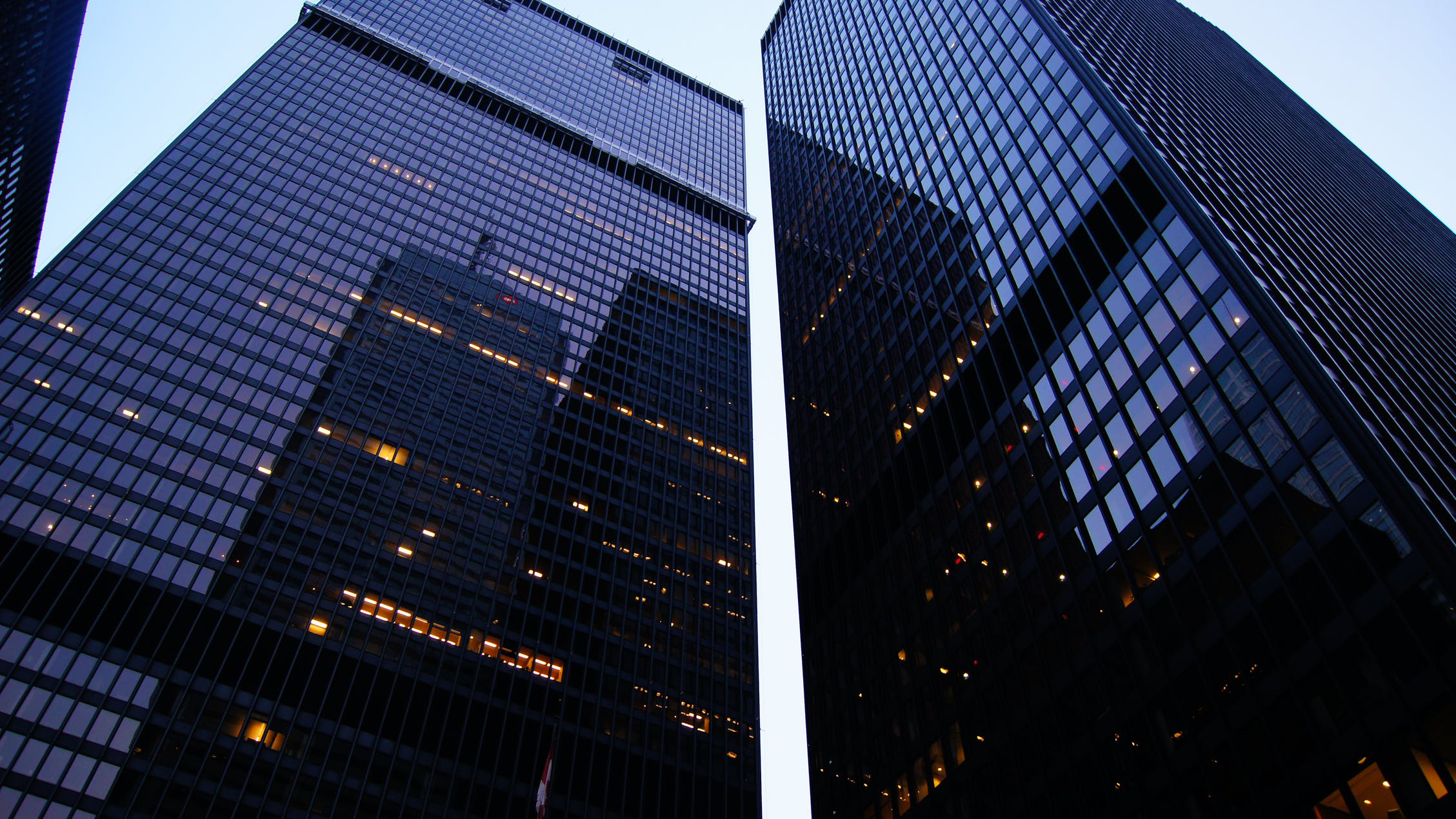 two tall black buildings that show a reflection