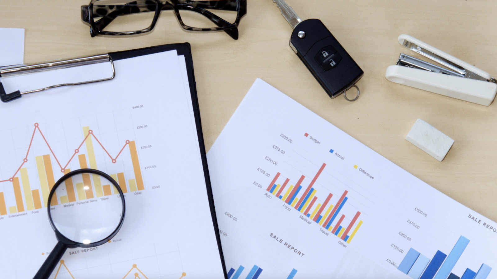 Printed charts on table with magnifying glass