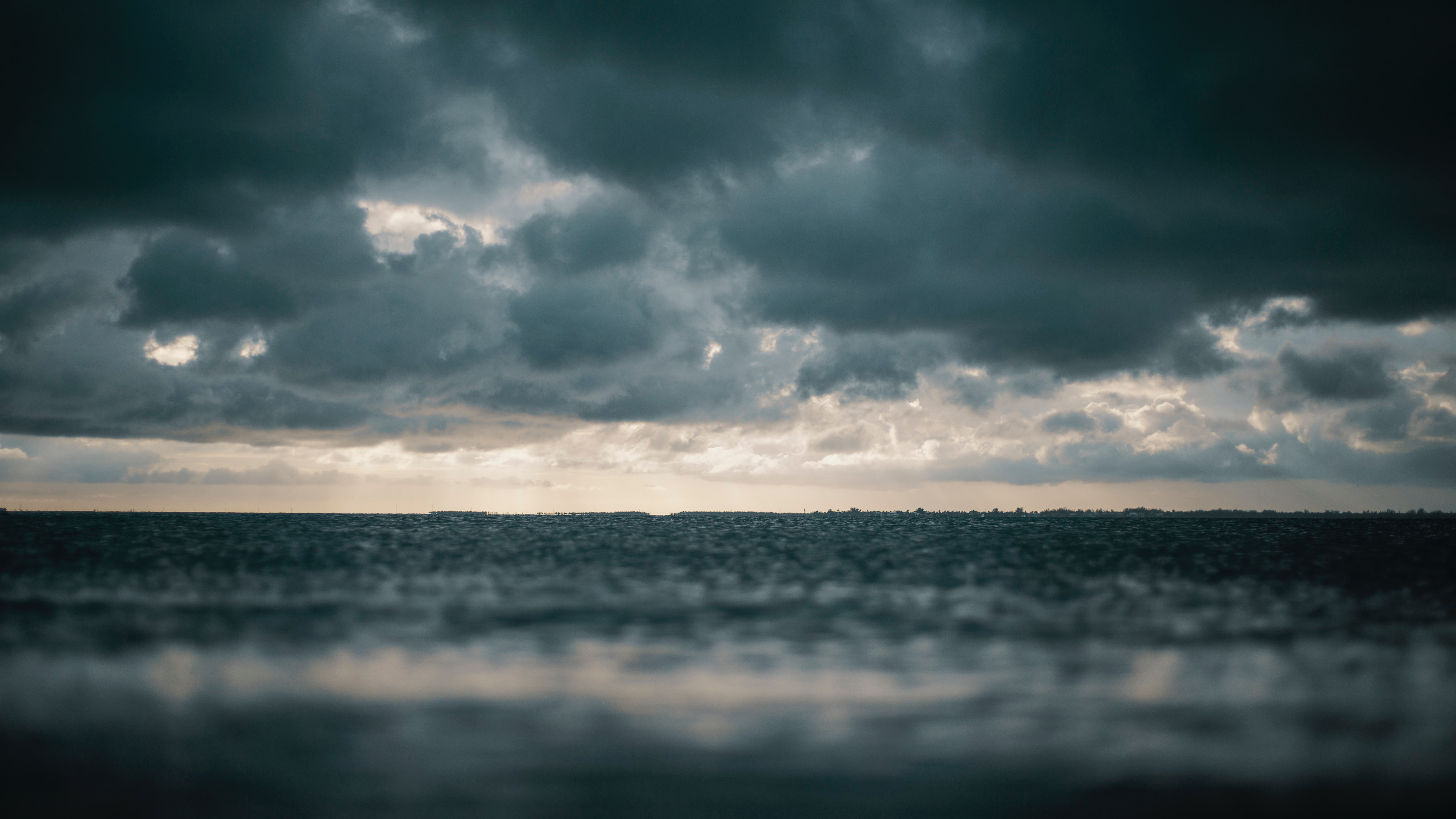 Body of water with dark clouds overhead