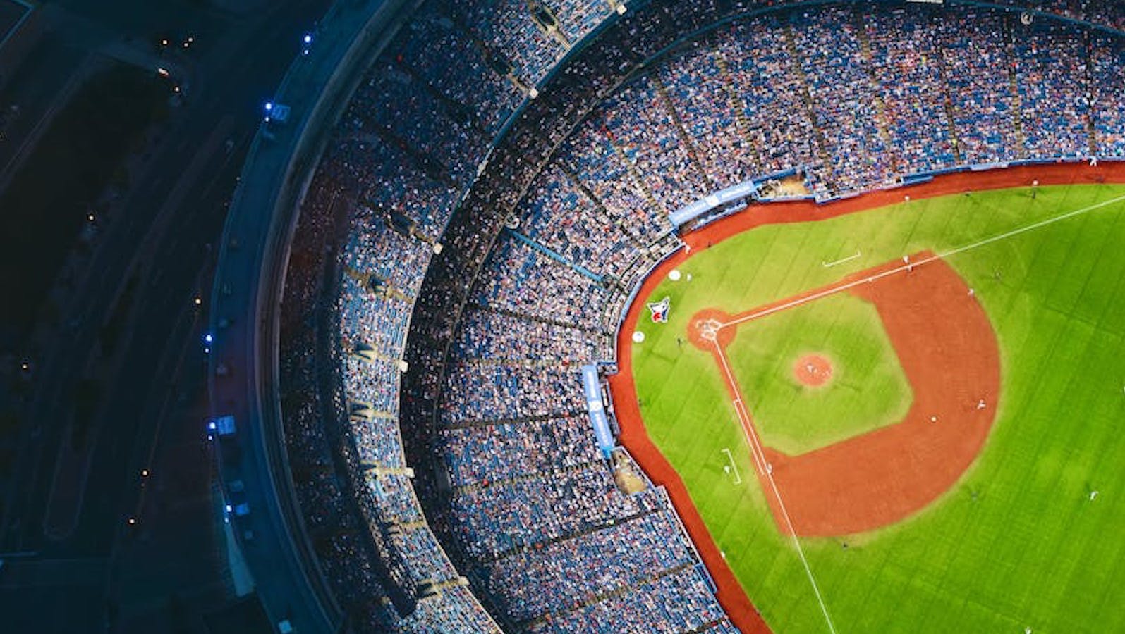 Overhead view of a baseball stadium at night with lights on