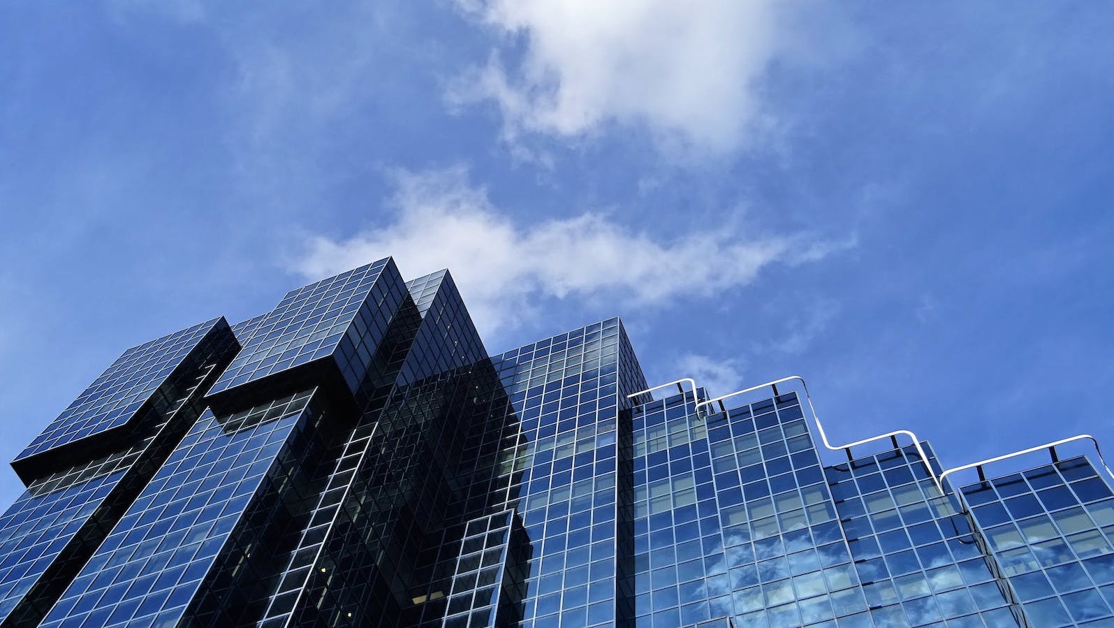 Tall glass window buildings against a blue sky