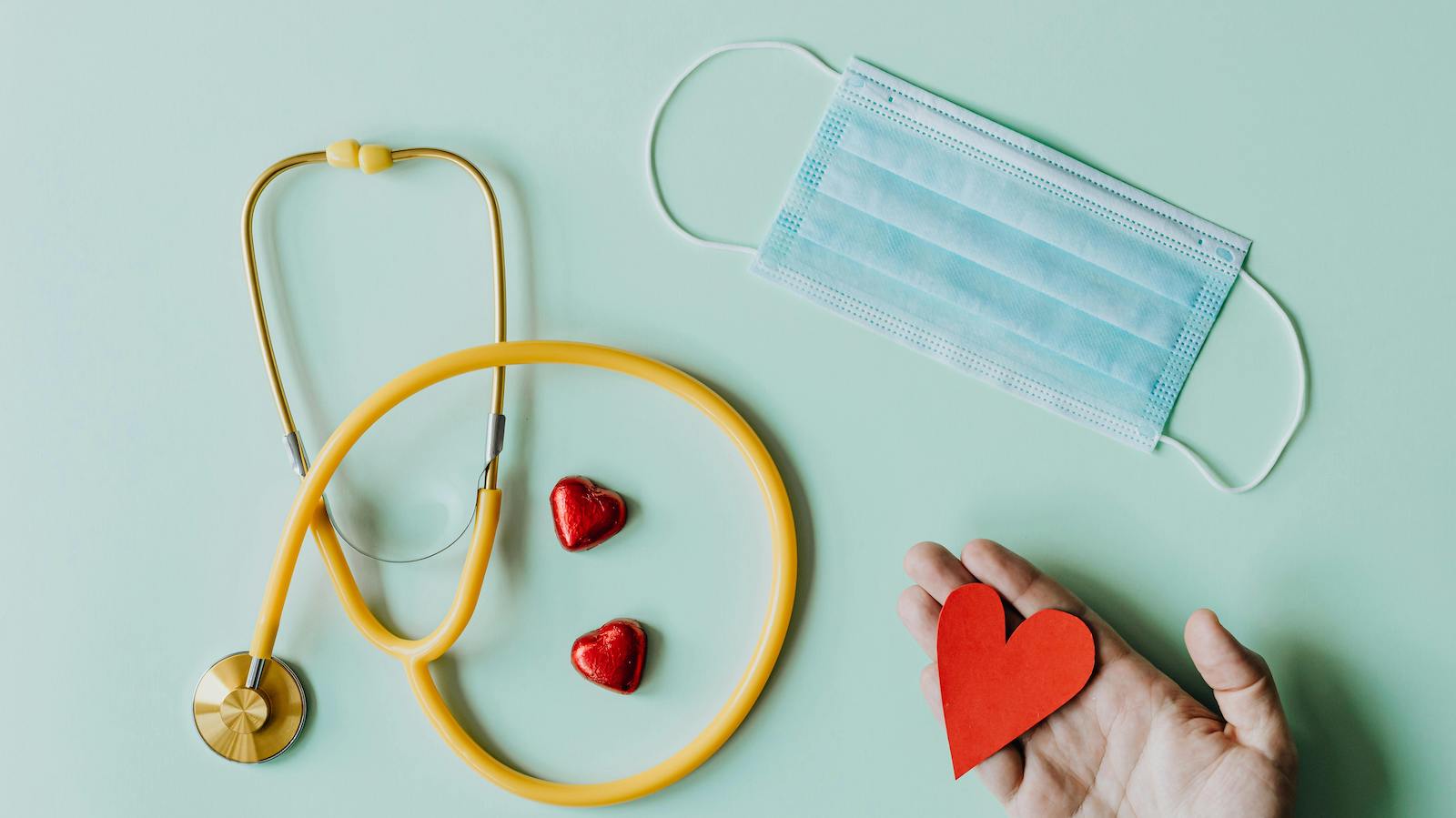 Medical stethoscope and mask composed with red foiled chocolate hearts