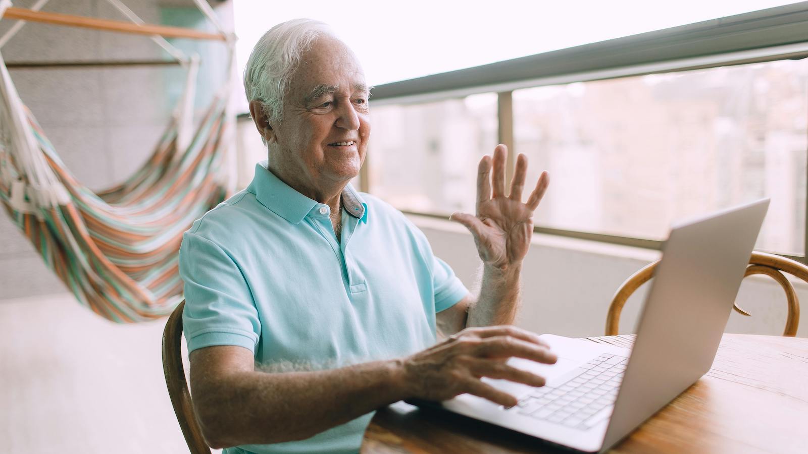 An Elderly Man Communicating via Laptop