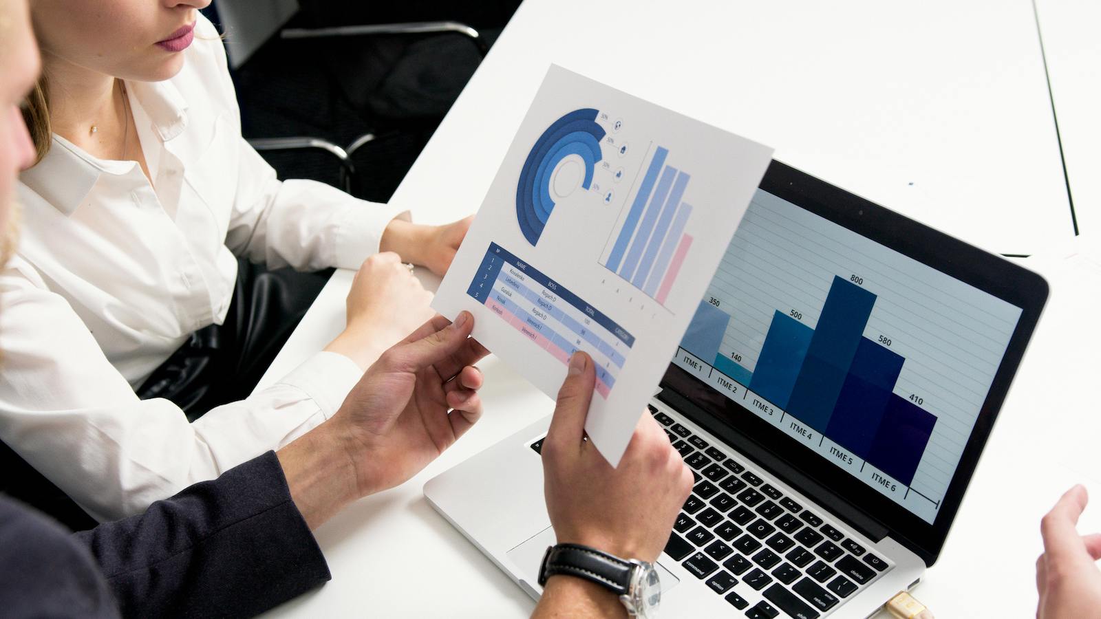  Person Holding Paper with White and Blue charts