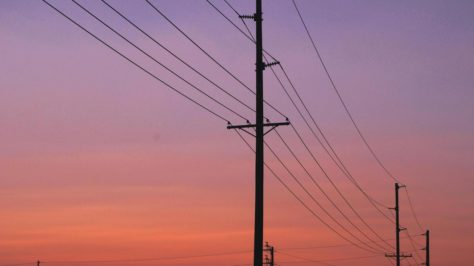 Silhouette of Electric Posts Under Red Sky