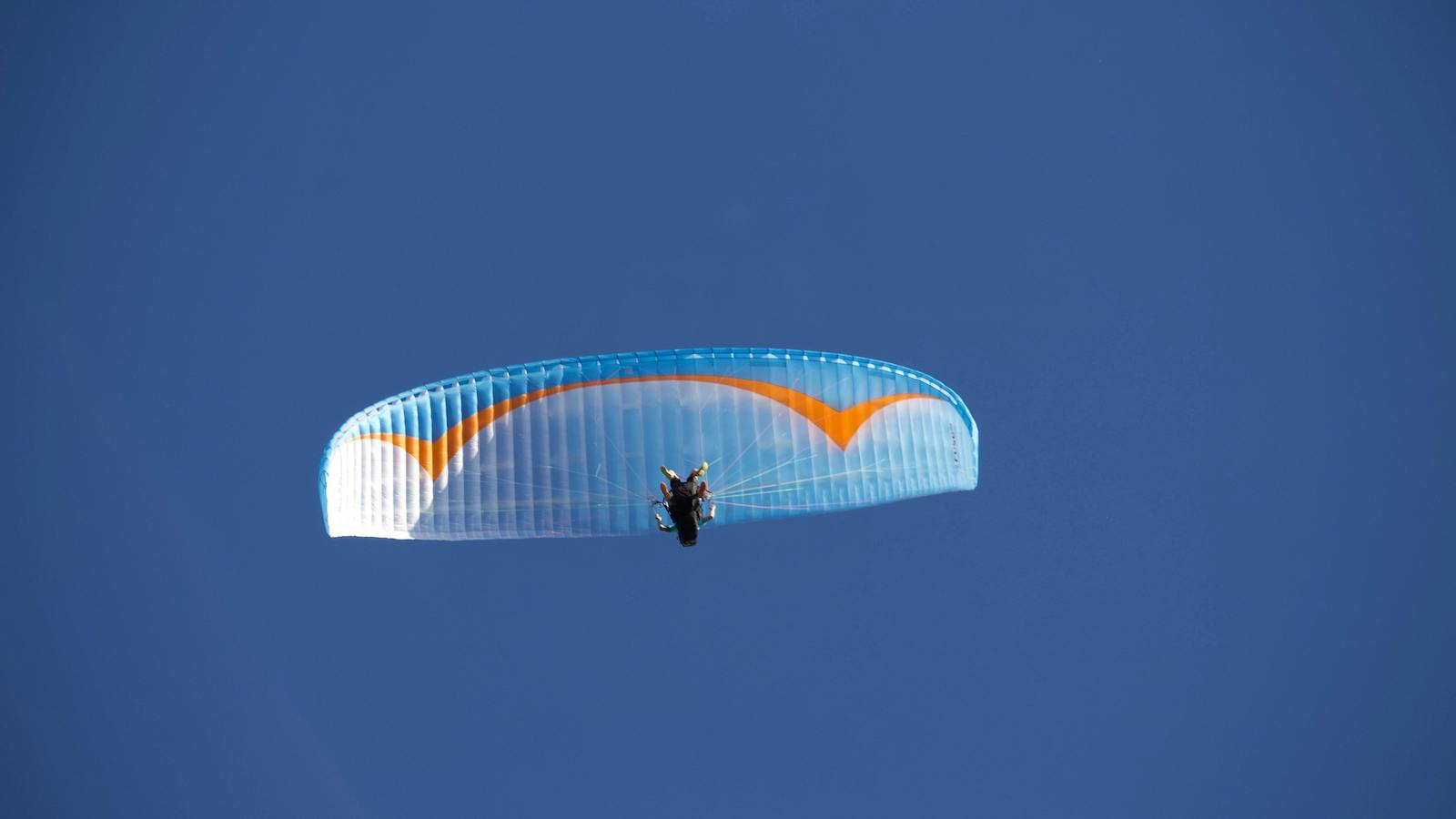 Unrecognizable paraglider flying in sky