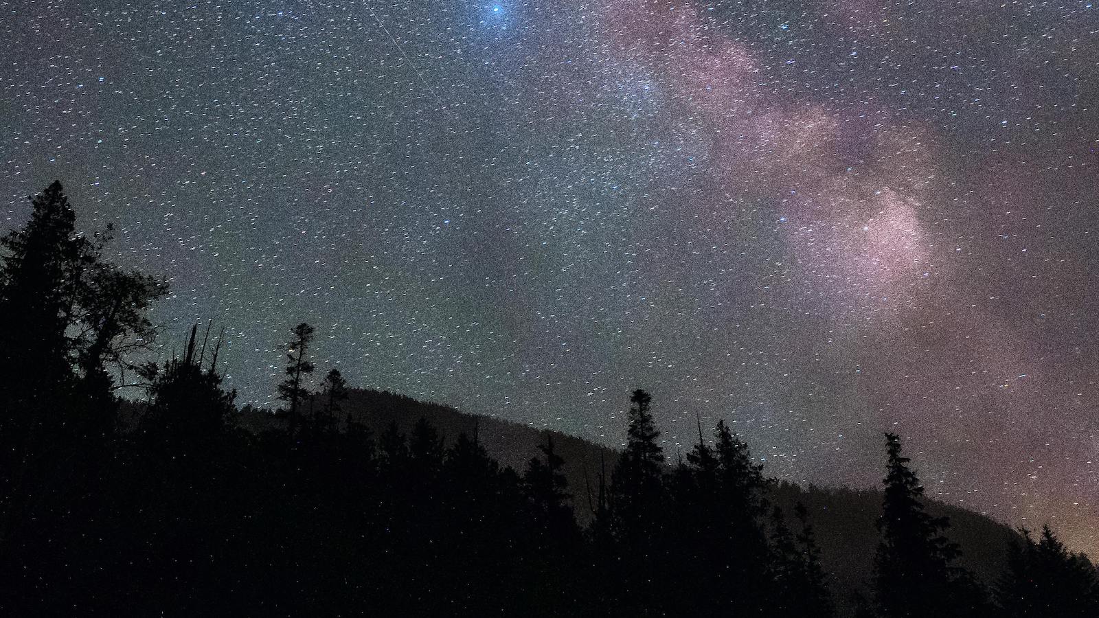 The milky way over the mountains in the night sky