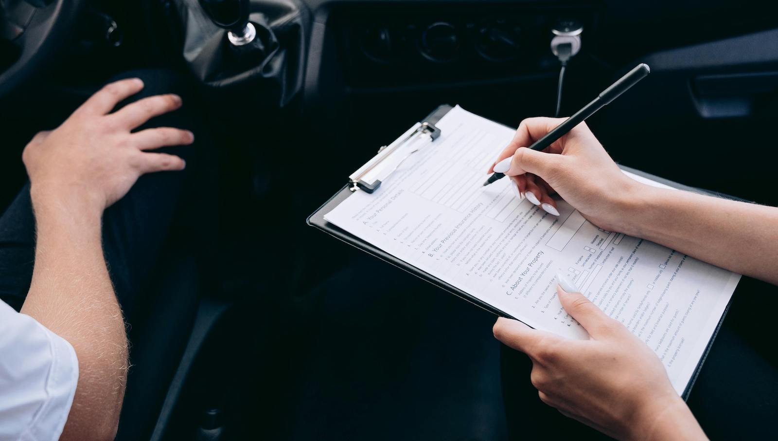 Person Writing on a Clipboard Inside the Vehicle