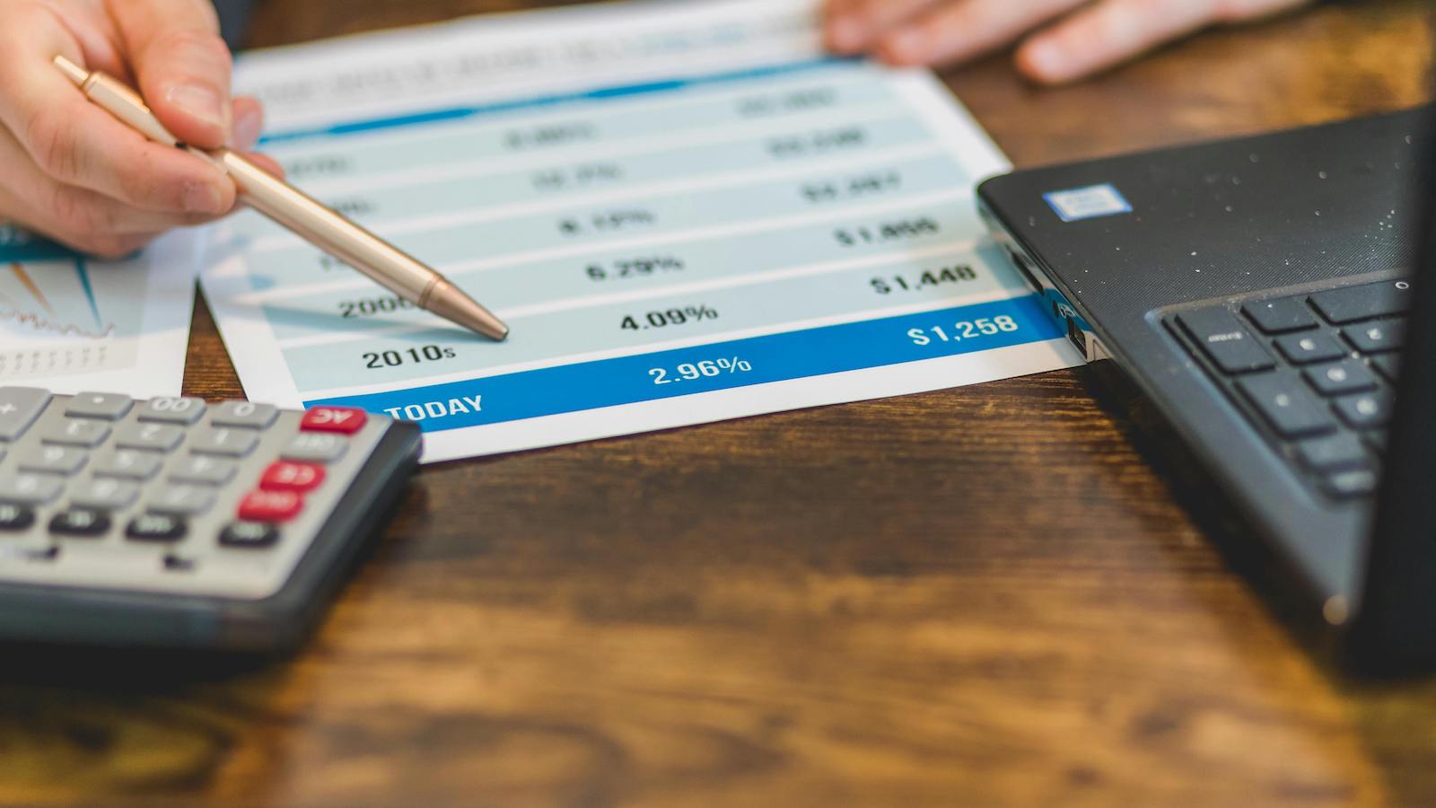 A Close-Up Shot of an Agent Pointing at Rates with a Ballpen