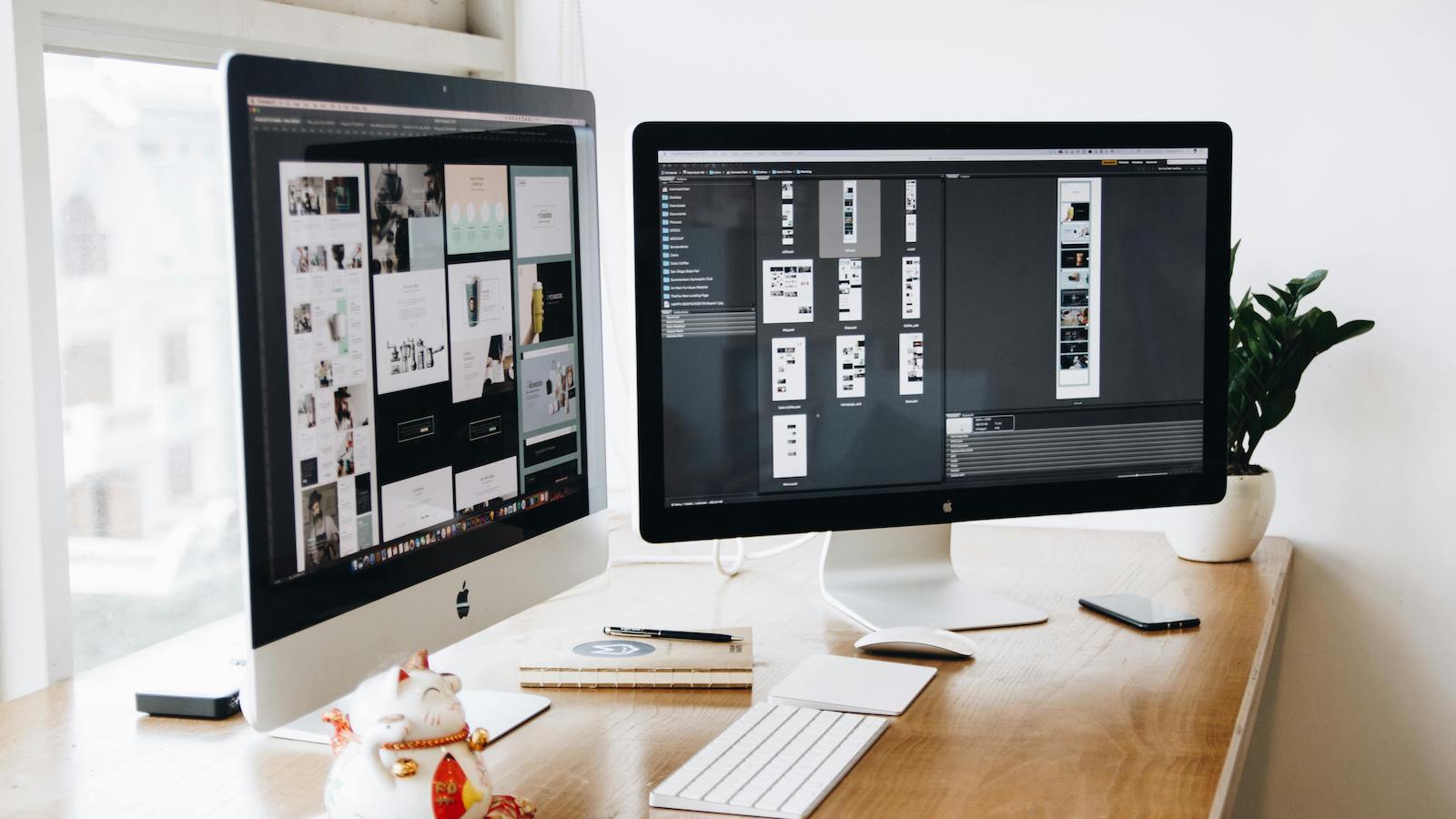 Two Imac's With Keyboard and Phones on Desk