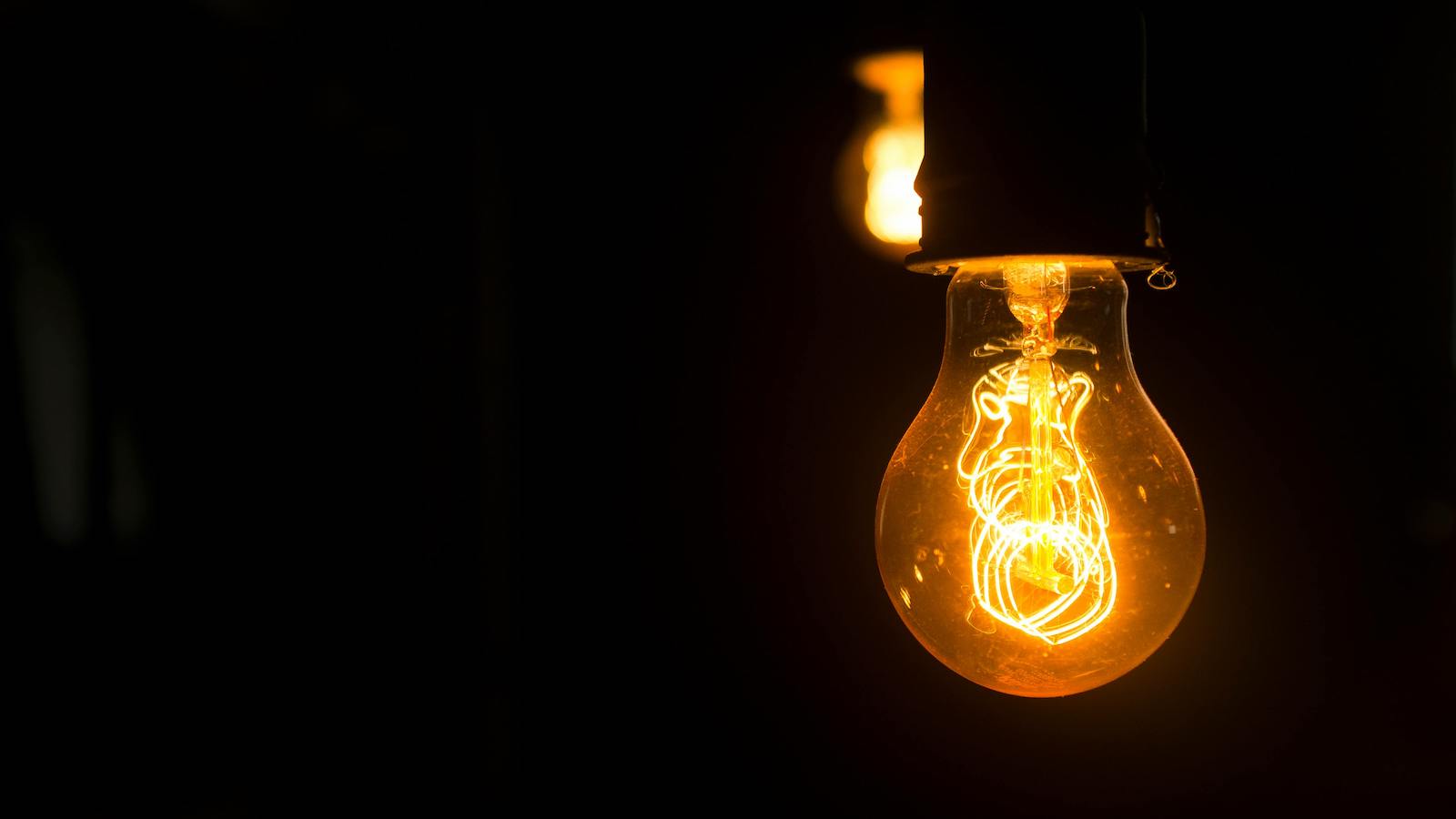 Close up of yellow light bulb in dark place