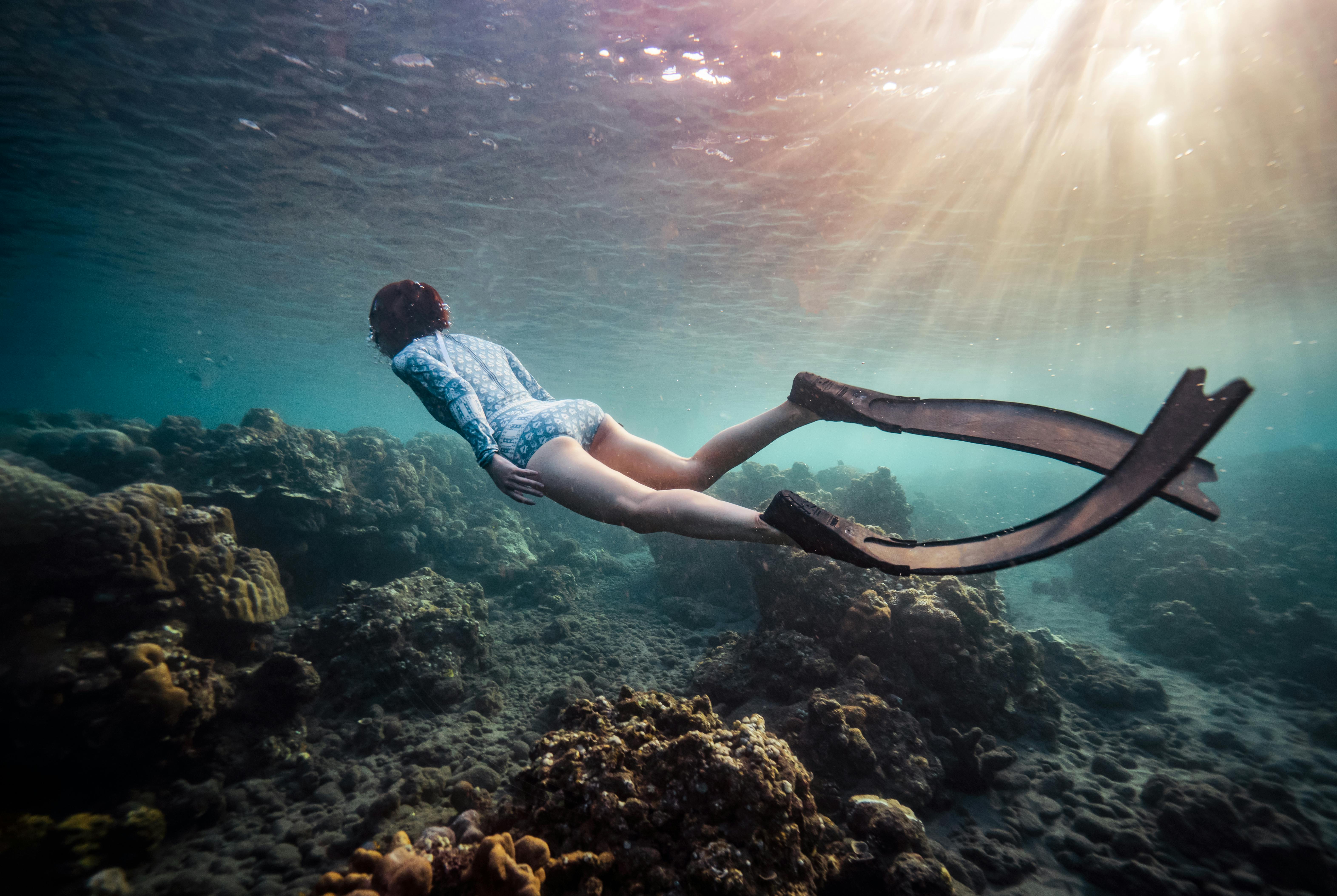 scuba diver over coral reefs