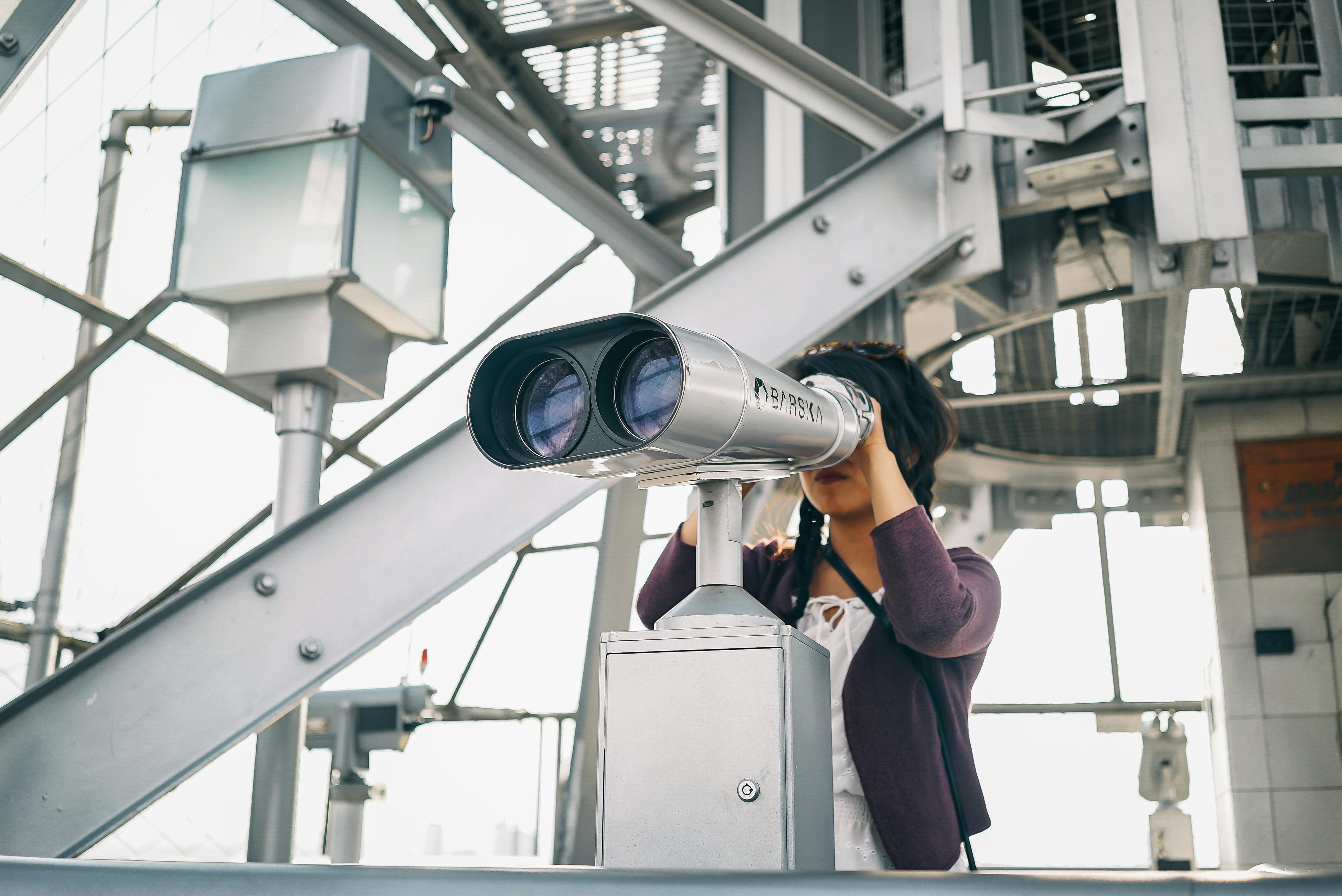 Woman in Purple Cardigan Using Binoculars