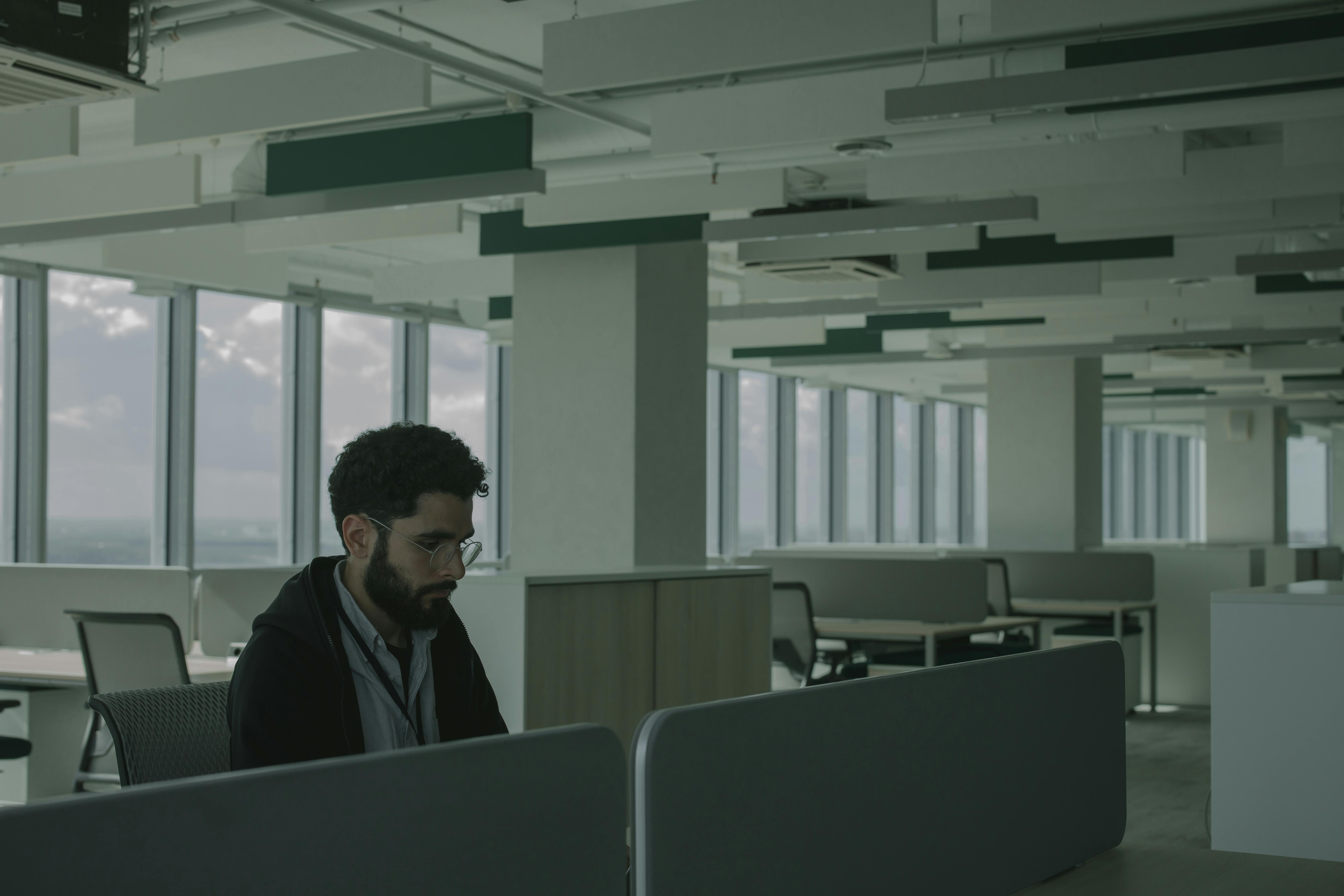 Man in Black Jacket Sitting on Chair in Empty Office