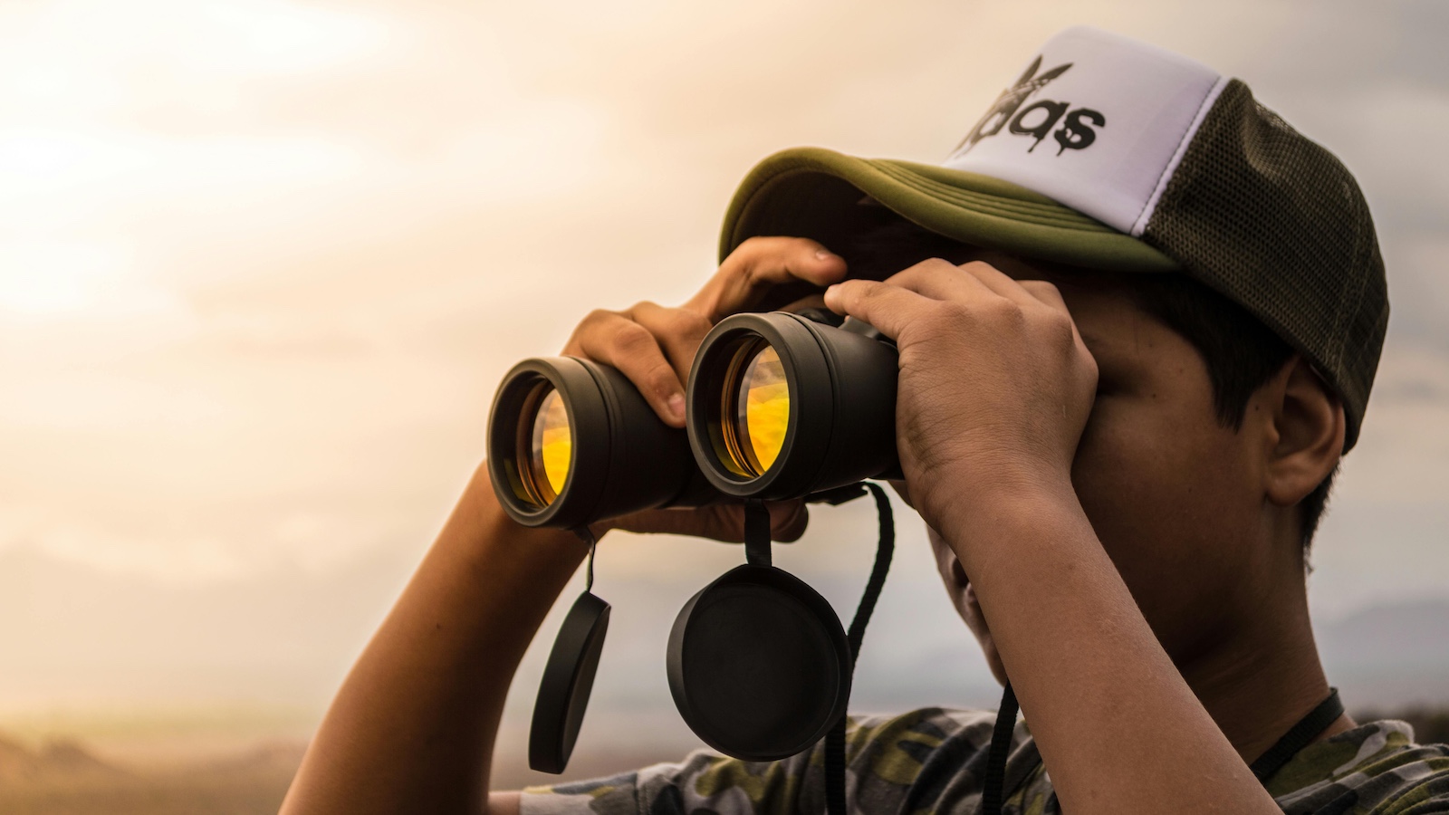 Man Looking in Binoculars during Sunset