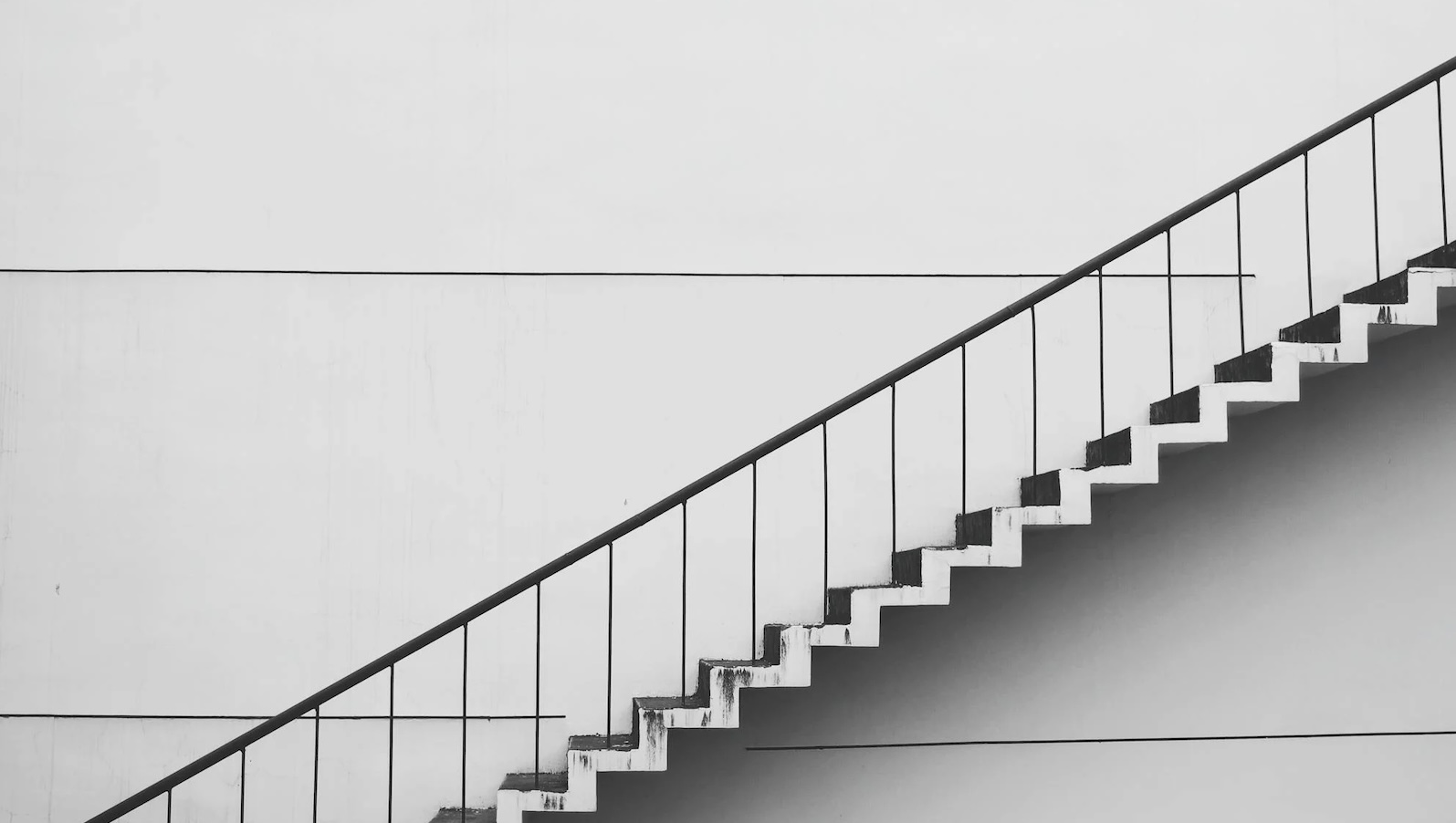 Grey and white staircase ascending against a solid white background