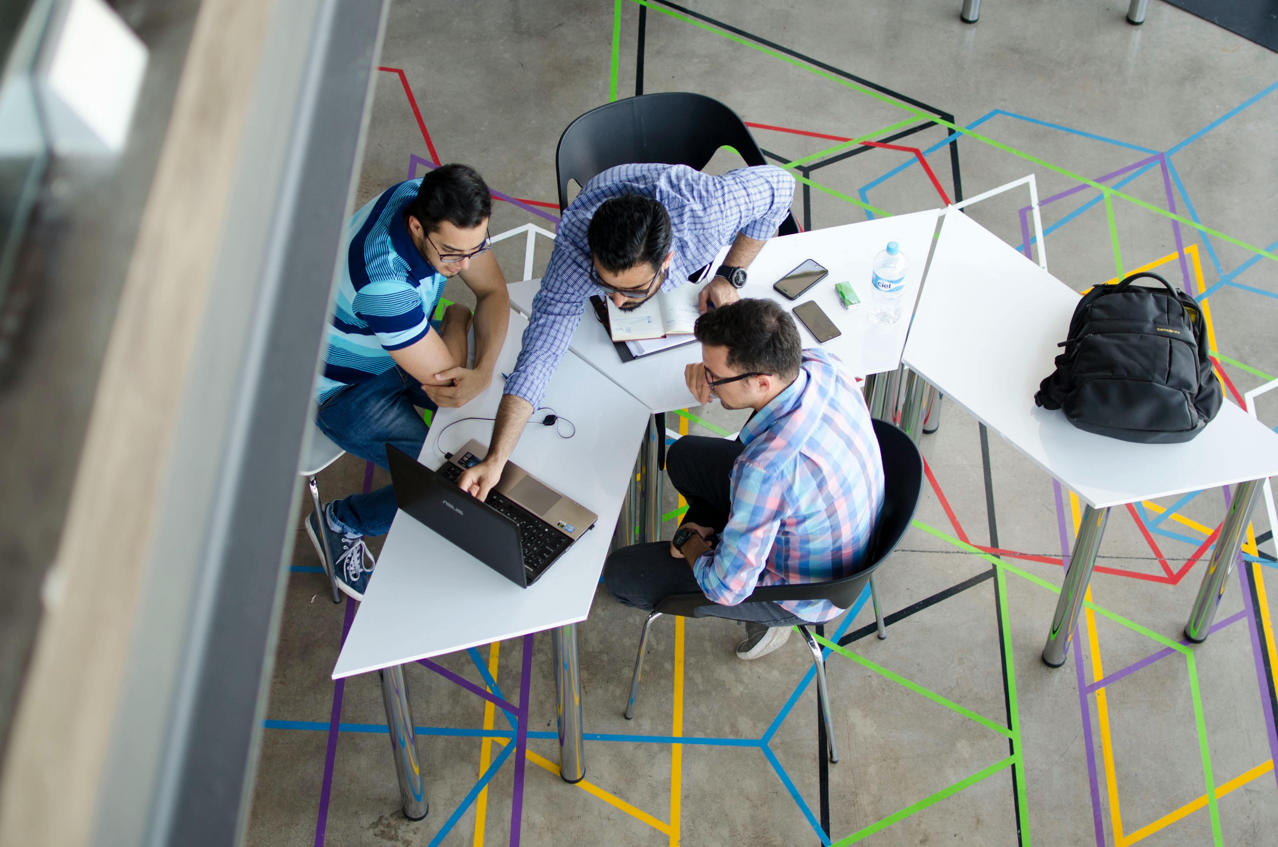 Top-view Photo of 3 Men in Front of Laptop