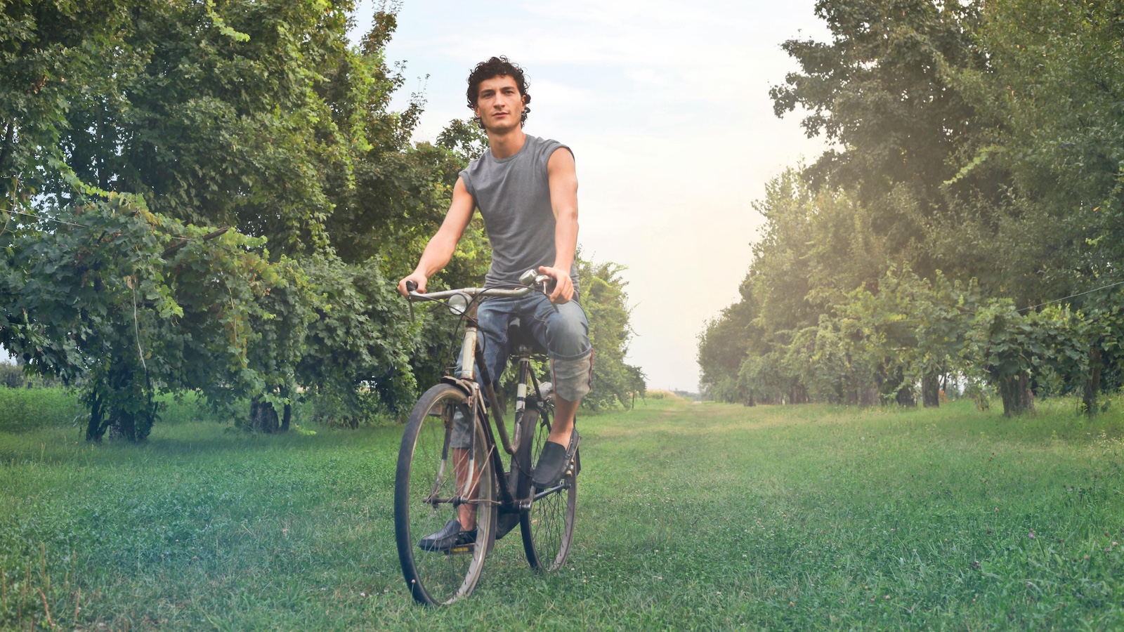 Man in Gray Sleeveless Shirt Riding Bike