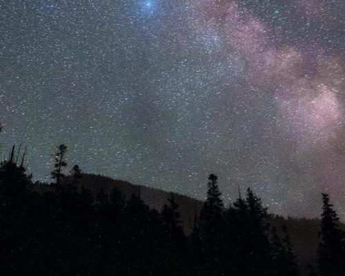 The milky way over the mountains in the night sky