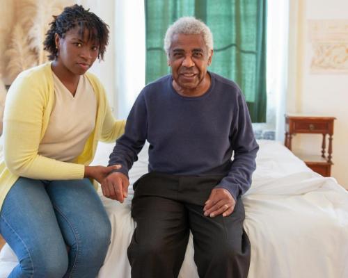 Woman and Elderly Man Sitting on Bed