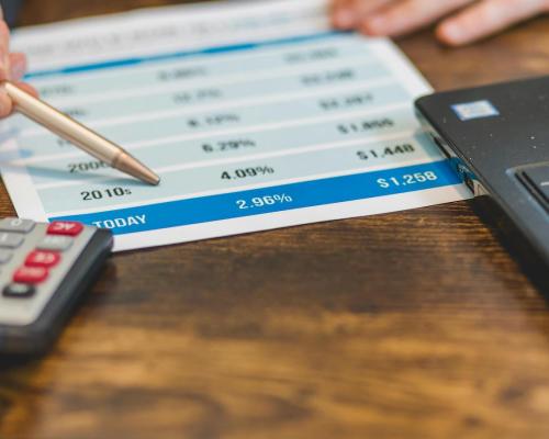 A Close-Up Shot of an Agent Pointing at Rates with a Ballpen