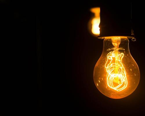 Close up of yellow light bulb in dark place