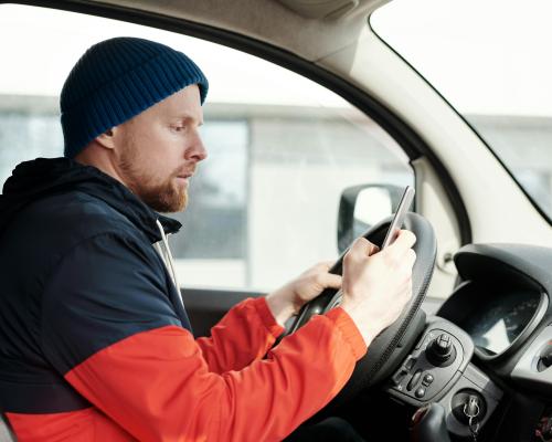 Man in Red and Black Jacket Driving Car