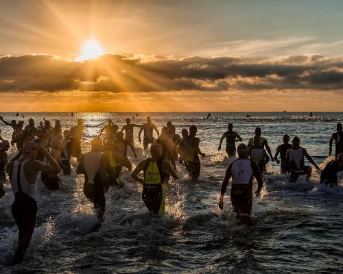 People Bathing in the Sea at Sunrise