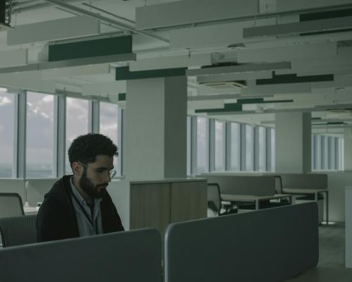 Man in Black Jacket Sitting on Chair in Empty Office